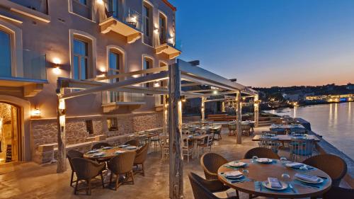 ein Restaurant mit Tischen und Stühlen neben dem Wasser in der Unterkunft Thalassa Boutique Hotel in Rethymno