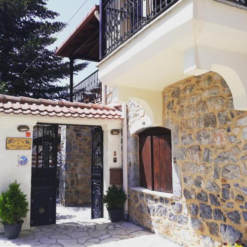 a building with a door and a stone wall at Archontiko Nikolopoulou in Vytina