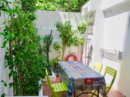 a table and chairs on a patio with plants at Clot MiraBarna Apartments in Barcelona