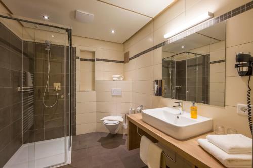 a bathroom with a sink and a shower and a toilet at Hotel Garni Klocker in Kaltenbach