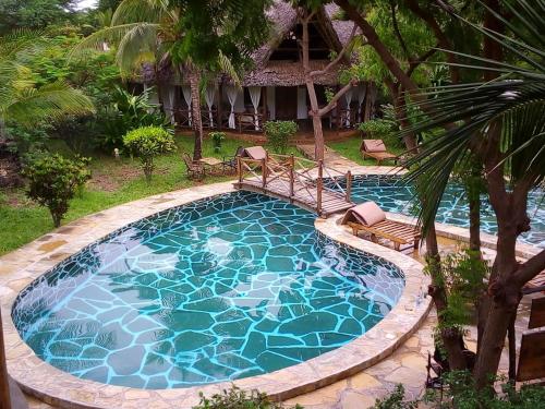 a swimming pool with a bridge in a resort at Marine Holiday House in Malindi