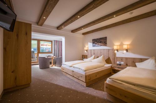 a hotel room with two beds and a television at Hotel Garni Klocker in Kaltenbach