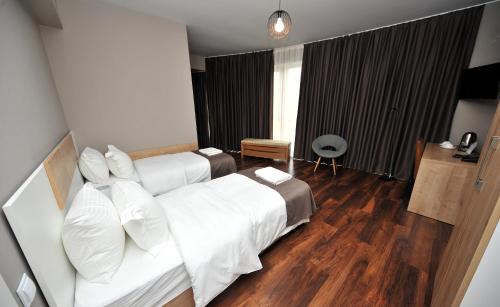 a bedroom with a large white bed with white pillows at Boho Tiflis Hotel in Tbilisi City