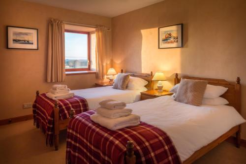 two beds in a hotel room with towels on them at Carden Holiday Cottages - Elgin in Crook of Alves
