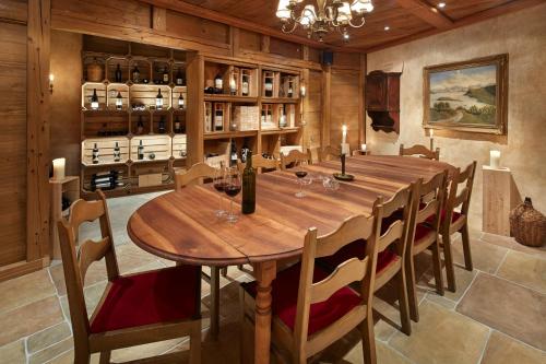 a dining room with a large wooden table and chairs at Alpenblick Weggis - Panorama & Alpen Chic Hotel in Weggis
