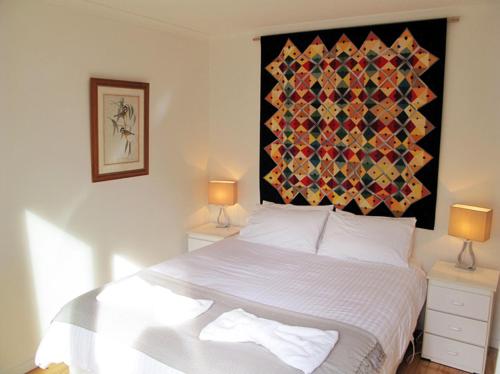 a bedroom with a large bed with a colorful headboard at Wattletree Cottage in Halls Gap