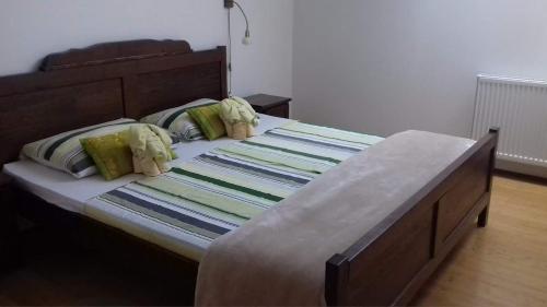 a bedroom with a large bed with a wooden headboard at Smještaj Slavonija in Daruvar