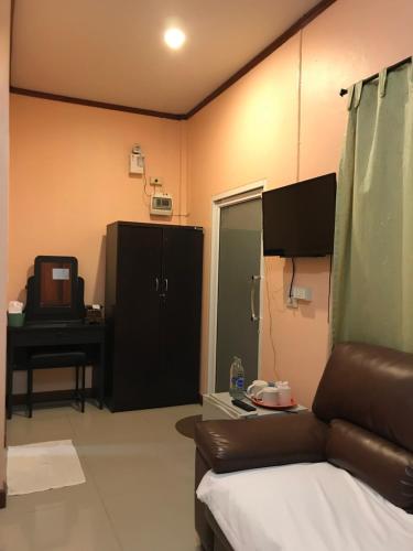 a living room with a couch and a table and a television at Green Leaf Resort in Surin