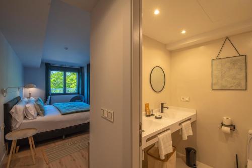 a bedroom with a bed and a bathroom with a sink at IXUA Hotela in Éibar