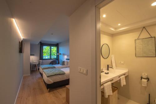 a bedroom with a bed and a bathroom with a sink at IXUA Hotela in Éibar