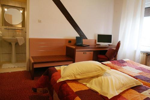 a bedroom with a desk and a bed and a computer at La Maison ERNENWEIN in Obermodern