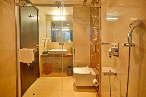 
a bathroom with a shower, sink, and toilet at Hotel Cross Lane in Ajmer
