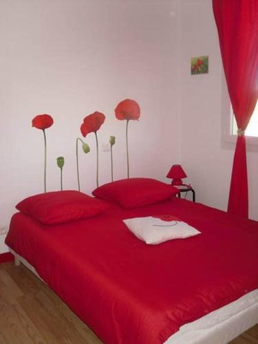 une chambre avec un lit rouge avec des oreillers rouges dans l'établissement Gîte Bien Etre, à Boulogne-sur-Gesse