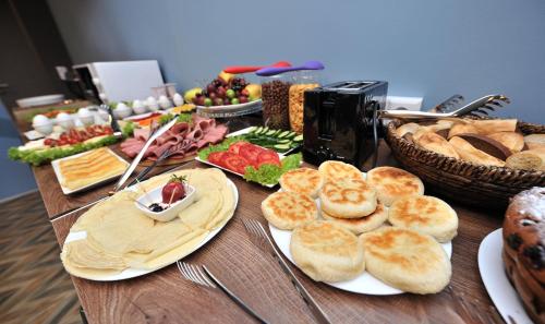 a table topped with plates of bread and other foods at Boho Tiflis Hotel in Tbilisi City