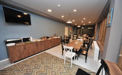a dining room with a table and a television at Boho Tiflis Hotel in Tbilisi City
