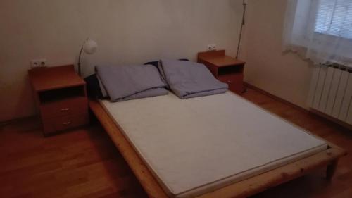 een groot bed in een kamer met 2 nachtkastjes bij Apartmán Eva in Vrbovec