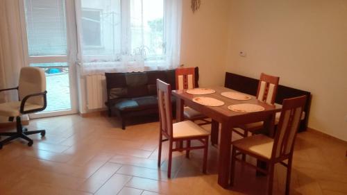een eetkamer met een tafel en stoelen en een bank bij Apartmán Eva in Vrbovec