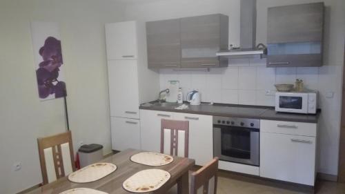 une cuisine avec une table en bois et 2 chaises dans l'établissement Apartmán Eva, à Vrbovec