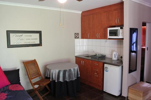 a small kitchen with a table and a microwave at Rusticana Hospitality Estate in Klapmuts