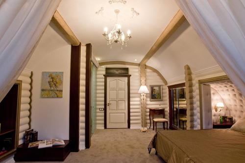 a bedroom with a large bed and a chandelier at Загородный отельно-ресторанный комплекс "Четыре сезона" in Pylypovychi