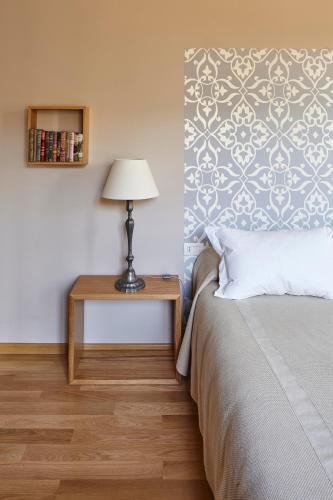 a bedroom with a bed and a table with a lamp at Agriturismo Tenuta la Pergola in Bardolino