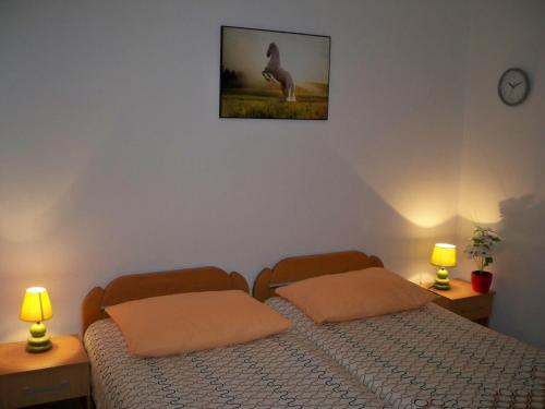 two beds in a bedroom with two lamps and a picture of a deer at Apartmani Perkovic in Baška Voda