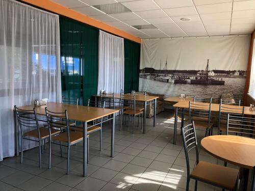 a restaurant with tables and chairs and a picture of a boat at Heltermaa Hostel in Heltermaa