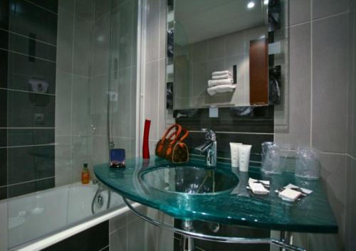 uma casa de banho com um lavatório verde e uma banheira em Convention Montparnasse em Paris