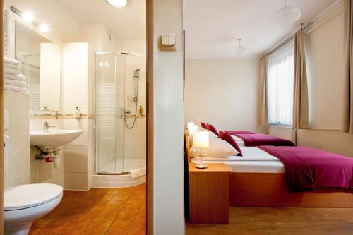 y baño con cama, aseo y lavamanos. en Mały Kraków Aparthotel en Cracovia