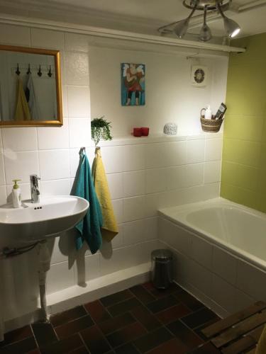 a bathroom with a sink and a bath tub at Heltoften Bed & Breakfast in Nykøbing Mors