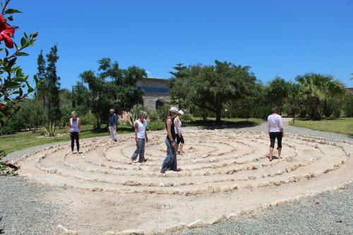 un grupo de personas de pie alrededor de un laberinto espiral en Douar Noujoum, en Essaouira