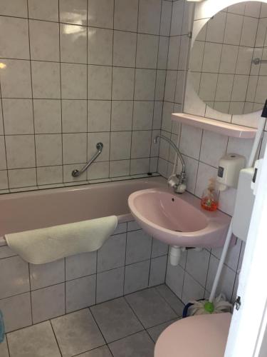 a bathroom with a sink and a tub and a toilet at Cuki Apartmanok in Si&oacute;fok