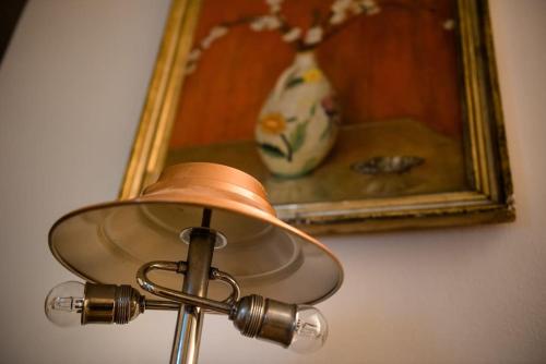 a lamp in front of a painting and a vase at San Matteo 23 in Genoa