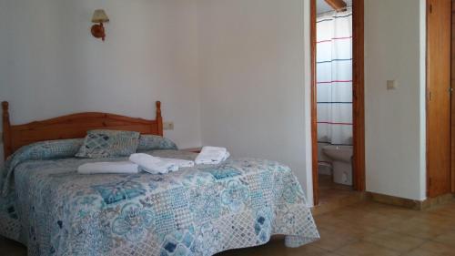a bedroom with a bed with two towels on it at Hostal Mini Golf in Los Caños de Meca