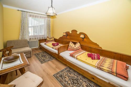 two beds in a room with yellow walls at Familie Lampersberger in Sachsenburg