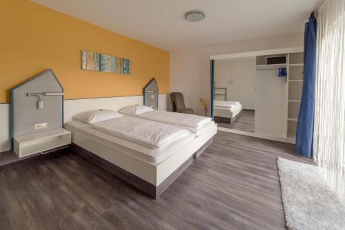 a bedroom with a large bed and a bathroom at Hotelpension Gästehaus Birgit in Bad Mergentheim