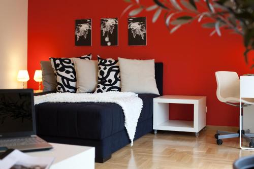 a living room with a couch and a red wall at Boutique Apartments 360º in Belgrade