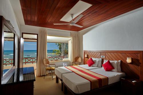 1 dormitorio con 1 cama y vistas al océano en Coral Sands Hotel, en Hikkaduwa