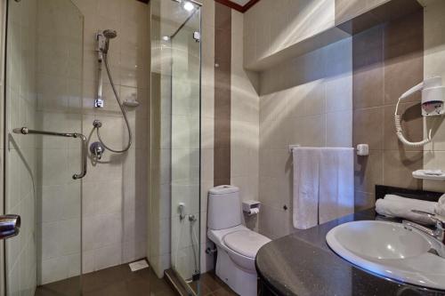 een badkamer met een douche, een toilet en een wastafel bij Coral Sands Hotel in Hikkaduwa