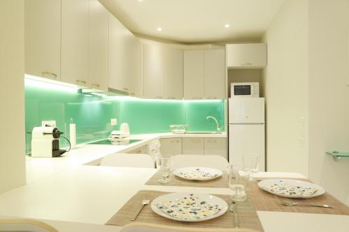 Una cocina con una mesa con platos y vasos encima. en Design Apartment in the City of Athens, en Atenas