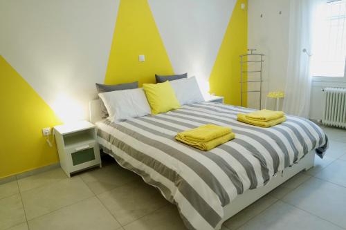 1 dormitorio con 1 cama grande y paredes amarillas en Design Apartment in the City of Athens, en Atenas