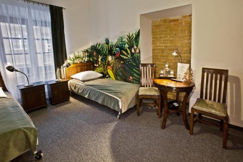a bedroom with a bed and a desk and a table at Castle Inn in Warsaw