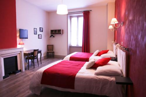 a hotel room with two beds and a fireplace at Hôtel du Midi in Annonay