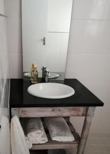 a bathroom with a sink and a mirror at Annika Self-catering and B&B in Stellenbosch