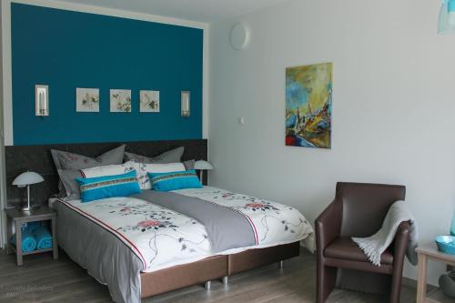 ein Schlafzimmer mit einem Bett und einem Stuhl in der Unterkunft Hotel Haus Kallenberg in Herbrechtingen