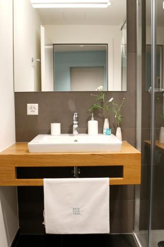 a bathroom with a sink and a mirror at Bata Club Haus in Möhlin