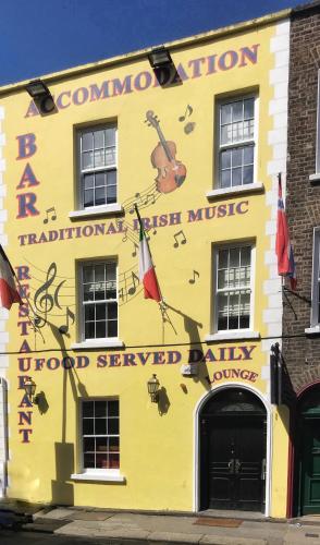 a yellow building with a violin painted on it at Molloy's Apartments in Dublin