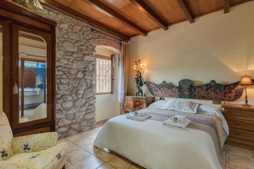 a bedroom with a large bed and a stone wall at Flateli Anglès in Anglés