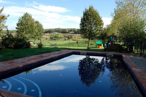 una piscina en un patio con árboles y un campo en Mas Duran en La Pera