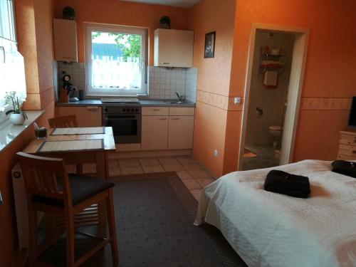 a small kitchen with a bed and a table and a desk at Gästehaus Celine in Meuspath